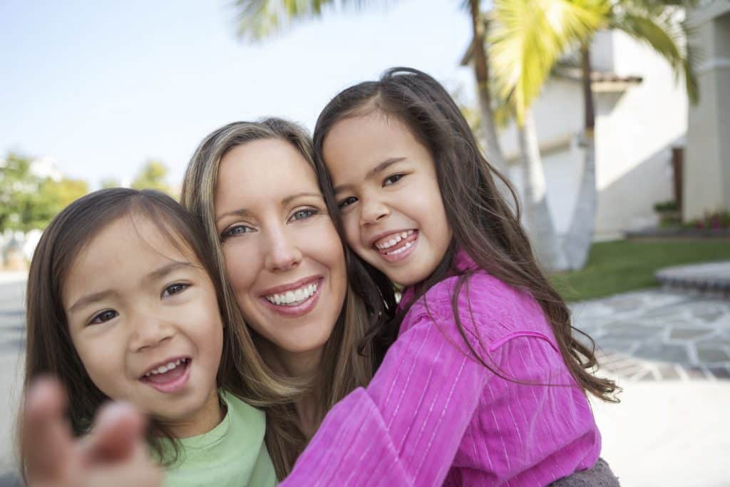 Mom and two daughters holding each other