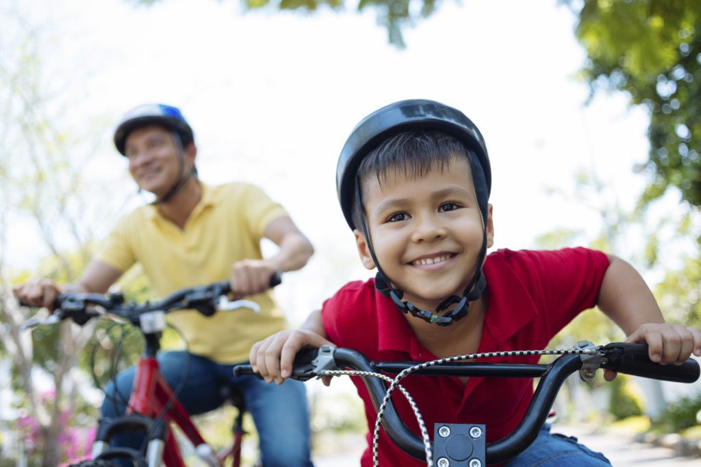 Little boy in helmet enjoying riding a bicycle