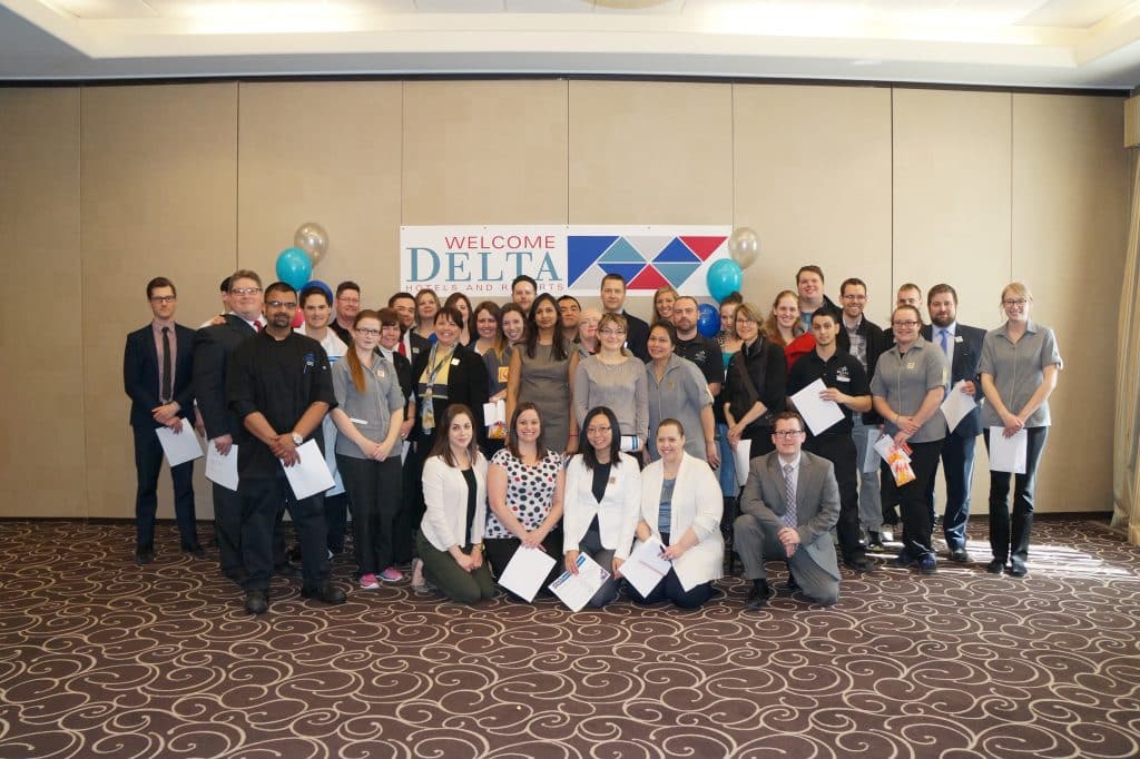 Delta Hotel group picture in an empty conference room