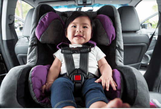 Little baby on a car seat smiling 