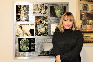 A young woman standing in front of a collage of images